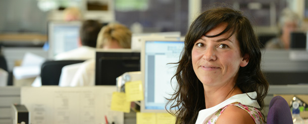 Staff yn eistedd wrth eu ddesgiau