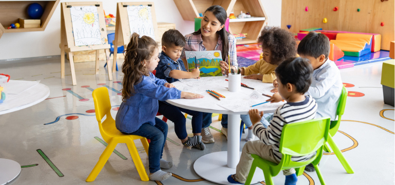 Teacher helping children with their art